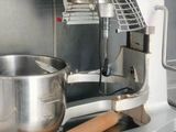 stainless steel counter top with a mixer and a wooden spatula on it