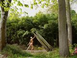 une femme debout dans l'herbe avec une planche de surf