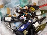 plusieurs bouteilles de vin dans un récipient en plastique posé sur la table