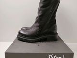 un gros plan sur une paire de bottes noires posées sur une boîte