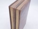 three books stacked on top of each other on a white surface