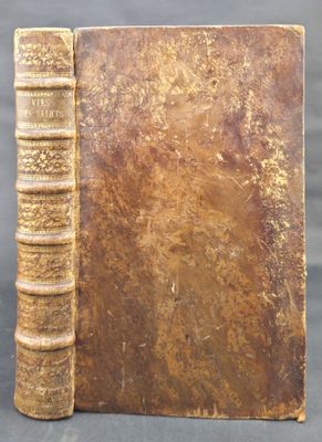 an old book sitting on top of a table next to a black background