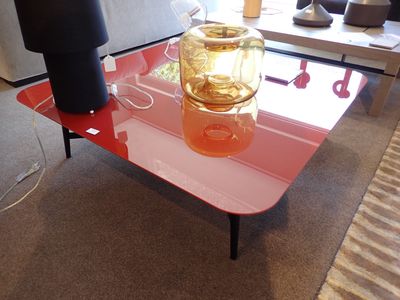 une table en verre sur laquelle se trouve un vase, dans un salon