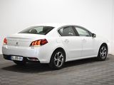 the rear end of a white car in a room with a checkered floor