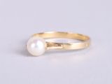 a close up of a pearl ring on a white surface