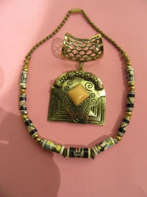 necklace with a gold pendant with a yellow stone on a pink background