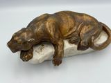 statue représentant un lézard assis sur un rocher, posée sur un fond blanc