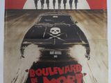 l'affiche du film « Boulevard La Mort », sur laquelle figure une voiture ornée d'un crâne et d'os croisés