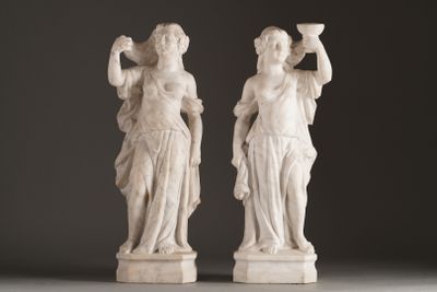 pair of white marble statues of a woman and a man holding cups
