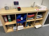 a wooden shelf with a blue backpack on top of it