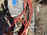 un tuyau rouge raccordé à un équipement rouillé
