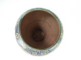 a close up of a vase on a white surface