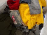 a pile of clothes and a can of soda on the floor