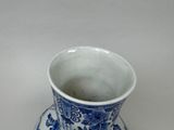 a blue and white cup and saucer sitting on a table