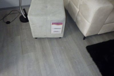 un pouf blanc posé dans un salon, à côté d'un tapis noir