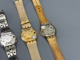 three different types of watches are shown on a gray surface