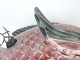 a figurine of a fish with a soccer ball on its head