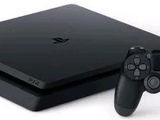 La console PlayStation 4 Slim de Sony se trouve à côté d'une manette PlayStation.