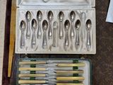 de nombreuses cuillères et fourchettes dans un coffret posé sur une table