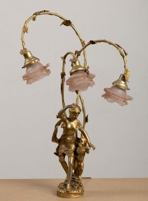 a gold statue of a man holding a lamp