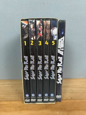 three dvd ' s sitting on top of a wooden table next to a blue wall