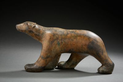 sculpture of a brown bear on a gray surface