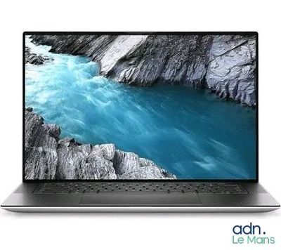 un gros plan d'un ordinateur portable posé sur une surface blanche, avec une rivière en arrière-plan