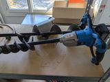 a blue and black drill on a workbench in a room