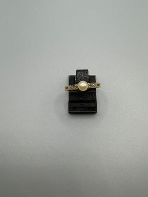 une bague en or avec une perle au centre