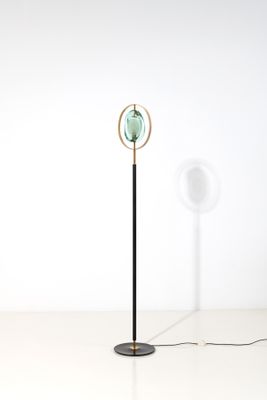 un lampadaire noir et doré surmonté d'un globe vert