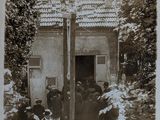 photograph of a group of people standing outside of a building