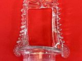un bougeoir en verre accroché à un mur rouge