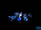 a close up of a bunch of blue crystals on a black surface