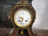 a clock that is sitting on a table in front of a fireplace