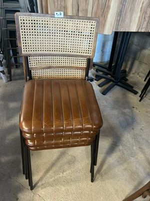 fauteuil en cuir marron avec dossier et assise tressés, dans un entrepôt