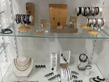 a glass display case with many different jewelry items on it