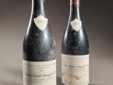 two bottles of wine sitting on top of a table next to each other