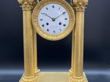 l'image d'une horloge en or posée sur une table