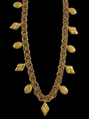 un collier en or orné de feuilles, suspendues à une chaîne