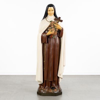 a statue of a woman holding a cross and wearing a robe