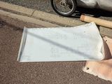 a piece of paper on the ground next to a motorcycle