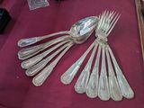 a lot of silver spoons and forks on a table