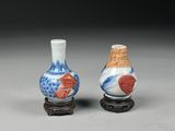 two small vases sitting on top of a table next to each other