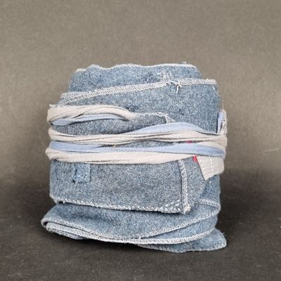 a stack of blue jeans wrapped in white string