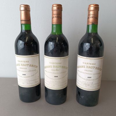 three bottles of red wine are lined up on a table