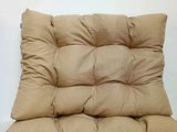 a tan cushion on a white table with a white wall in the background