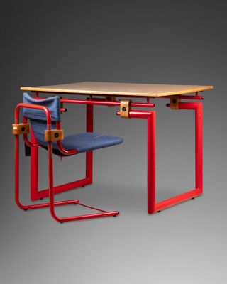 une image représentant un bureau rouge sur lequel est posée une chaise bleue