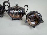 three silver teapots sitting on a white table