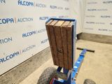 a cart with a wooden crate on it in front of a wall