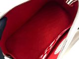 the inside of a white purse with a red lining